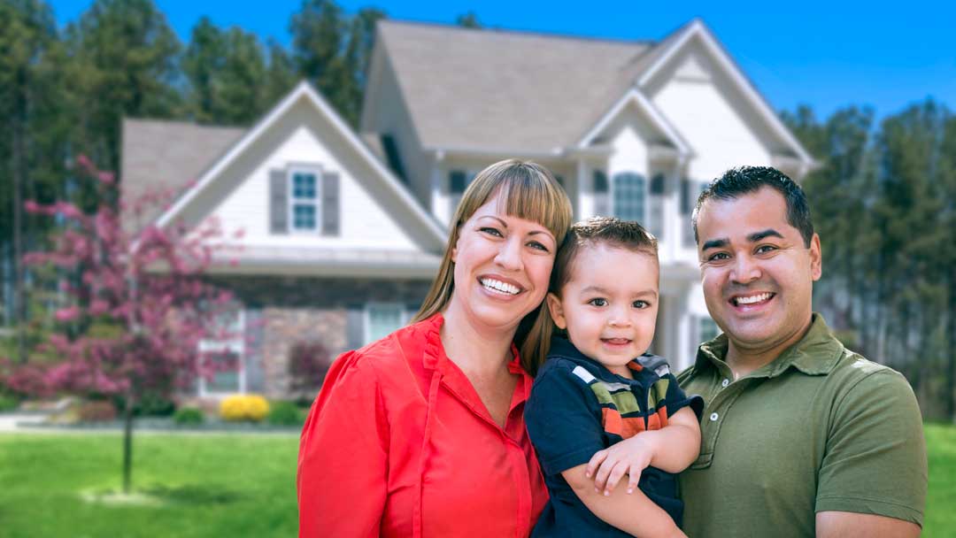 Young family in front of their new house