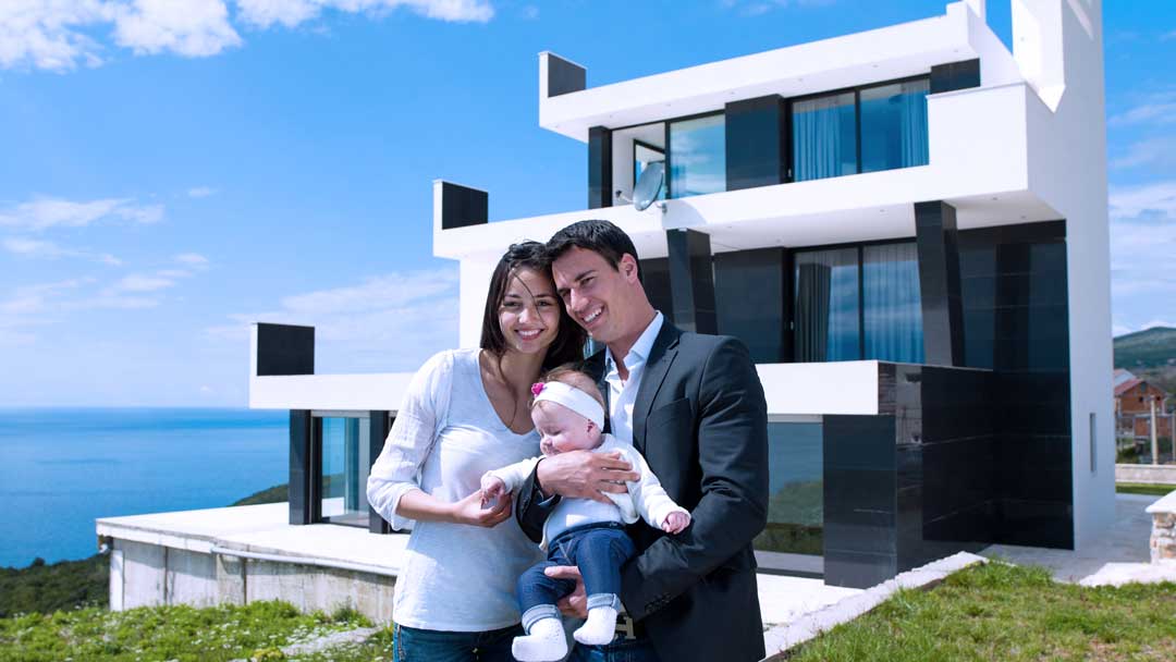 young family in front of their new luxury house